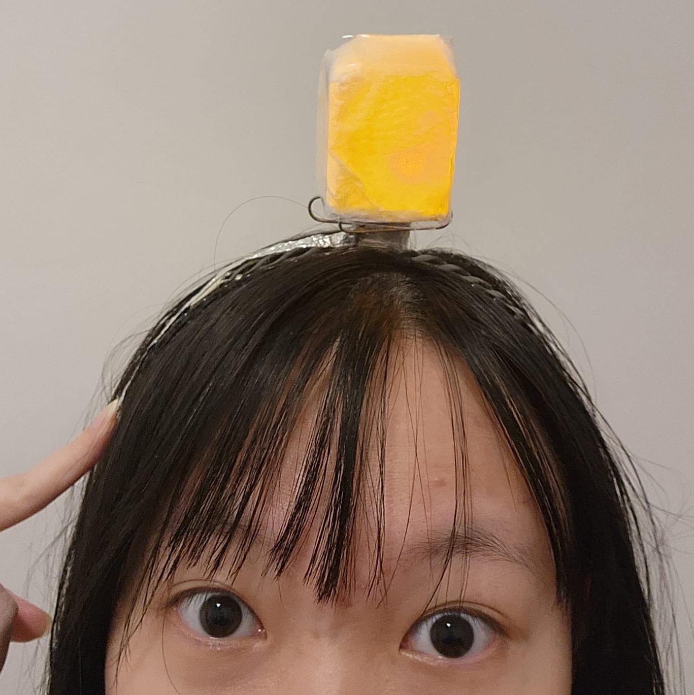 Light bulb headband that lights up when temple is touched to mimic having an idea
